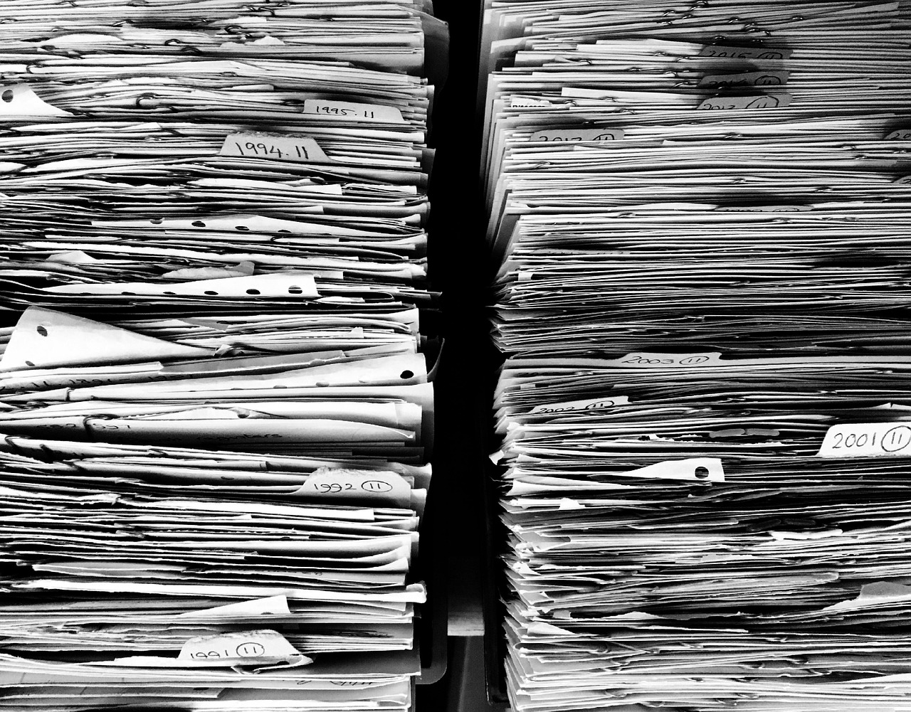 A thick stack of paper files and folders